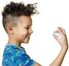 Photo of little boy holding aligners